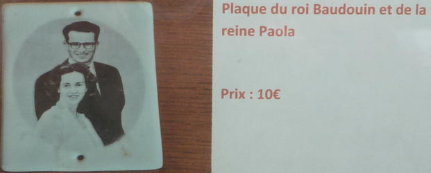 Photo d'une plaque à la devanture d'une maison, montrant Baudouin et Fabiola jeunes, avec la mention «Plaque du roi Baudouiin et de la Reine Paola [sic]. Prix: 10€»