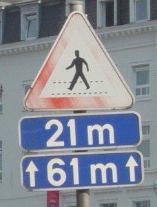 Panneau de signalisation avertissant d'un passage pour piétons à 21m, sur une distance de 61m